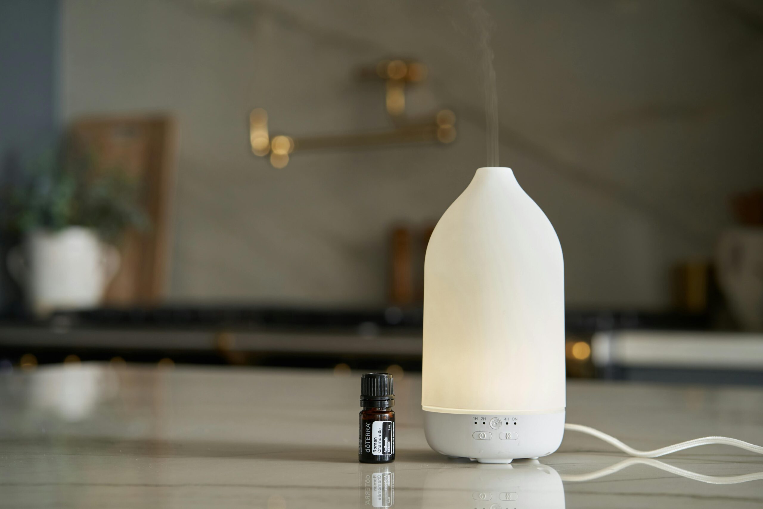 Minimalist diffuser with essential oil bottle on kitchen countertop, exuding a calming atmosphere.